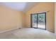 A carpeted room featuring a vaulted ceiling with a sliding glass door leading to a deck at 7500 E Dartmouth Ave # 22, Denver, CO 80231