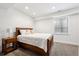 Cozy bedroom featuring a wooden bed frame, plush bedding, and a nightstand with a lamp at 1644 S Lafayette St, Denver, CO 80210