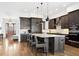 Modern kitchen with a large island, stainless steel appliances, and dark wood cabinets at 1644 S Lafayette St, Denver, CO 80210