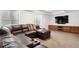 Spacious living room with a large leather sectional sofa, media cabinet, and a wall-mounted television at 1644 S Lafayette St, Denver, CO 80210