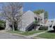 Inviting multi-story exterior with a black staircase, tan siding, and well-manicured lawn and landscape at 13633 E Yale Ave # B, Aurora, CO 80015