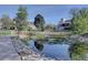 Scenic community pond with a walking path, water lilies, landscaping, and reflections of the surrounding homes at 13633 E Yale Ave # B, Aurora, CO 80015