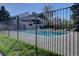 Community pool surrounded by a secure fence, green grass, and lounge chairs on the pool deck at 13633 E Yale Ave # B, Aurora, CO 80015