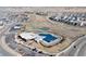 Aerial view of community pool, tennis courts, clubhouse, parking, and residential area of neighborhood with mountain views in the distance at 12628 Bayshore St, Firestone, CO 80504