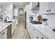 Bright kitchen featuring white cabinets, quartz countertops, and stainless steel appliances at 12628 Bayshore St, Firestone, CO 80504
