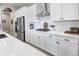 Modern kitchen with white cabinets, quartz countertops, and stainless steel appliances at 12628 Bayshore St, Firestone, CO 80504