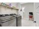 Well-equipped laundry room with a front-load washer and dryer, plus shelving for storage at 12628 Bayshore St, Firestone, CO 80504