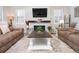 Comfortable living room with plush seating, a stone fireplace with a mounted TV, and modern décor, offering a relaxing ambiance at 12628 Bayshore St, Firestone, CO 80504