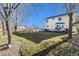 View of a backyard with a patio, grass, and a house with yellow siding at 6184 Clayton St, Frederick, CO 80530