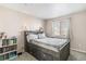 This bedroom features a bed with storage, a bookshelf, and tan-painted walls at 6184 Clayton St, Frederick, CO 80530