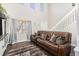 Spacious living room with high ceilings, hardwood floors, and a cozy leather sofa at 6184 Clayton St, Frederick, CO 80530