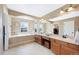Bright bathroom featuring a soaking tub, double vanity, and large mirror at 10633 Wynspire Way, Highlands Ranch, CO 80130