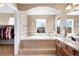 Bright bathroom featuring a soaking tub, double vanity, and walk-in closet at 10633 Wynspire Way, Highlands Ranch, CO 80130