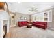 Cozy living room with a fireplace, ceiling fan, and comfortable red sofas at 10633 Wynspire Way, Highlands Ranch, CO 80130
