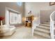 Two-story living room with a cozy armchair, stairway, and large picture window at 10633 Wynspire Way, Highlands Ranch, CO 80130