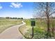 Scenic neighborhood walking path through a green space with a sign listing community rules at 10633 Wynspire Way, Highlands Ranch, CO 80130