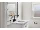 Bathroom features a sleek black faucet, marbled countertop, and a bright window for natural light at 11640 W 13Th Ave, Lakewood, CO 80401