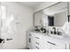 Bathroom featuring a double vanity with elegant fixtures, undermount sinks, and a decorative mirror at 11640 W 13Th Ave, Lakewood, CO 80401