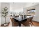 Open dining area with a dark wood table, woven chairs, hardwood floors, and a view into the bright living room at 11640 W 13Th Ave, Lakewood, CO 80401