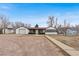 Single-story home with detached garage and stone driveway on a clear day, perfect for Gathering living at 11640 W 13Th Ave, Lakewood, CO 80401