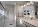 Modern bathroom with double sinks, marble countertop, and a shower with white tile surround at 1200 Sugarloaf Ln, Erie, CO 80516