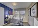 Bright bedroom featuring a striped bedspread, blue accent wall, and baseball-themed decor at 1200 Sugarloaf Ln, Erie, CO 80516