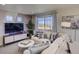 Cozy living room featuring a comfortable white sofa, decorative pillows, and large windows for natural light at 1200 Sugarloaf Ln, Erie, CO 80516