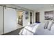 Bedroom with a view into a large bathroom through a sliding white barn door and a walk-in closet at 1200 Sugarloaf Ln, Erie, CO 80516