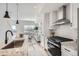 Stylish kitchen with modern appliances, white cabinets, granite countertops, and an adjacent living area at 15282 W 69Th Pl, Arvada, CO 80007