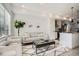 Bright living room showcasing neutral decor, modern furniture, and an open layout connected to the kitchen at 15282 W 69Th Pl, Arvada, CO 80007