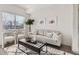 Sunlit living room with stylish furnishings, decorative artwork, and a view from the window at 15282 W 69Th Pl, Arvada, CO 80007