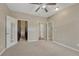 Spacious bedroom featuring carpet, a ceiling fan, closet space, and an en suite bathroom at 980 S Locust St # D, Denver, CO 80224