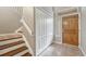 Welcoming entryway with wood door, tile floors, and staircase, offering a glimpse of the home's interior at 980 S Locust St # D, Denver, CO 80224
