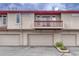 Exterior view of property featuring garage doors and second story balcony at 980 S Locust St # D, Denver, CO 80224