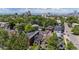 Aerial view of a neighborhood featuring lush trees and a stunning city skyline in the background at 1365 Clayton St, Denver, CO 80206