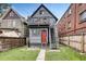 View of the backyard featuring a home with a second story balcony and an access staircase in a fenced yard at 1365 Clayton St, Denver, CO 80206