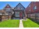 Backyard featuring a small grass area, stairs to a deck, and a red door at 1365 Clayton St, Denver, CO 80206