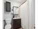 Functional bathroom with a vanity, mirror, toilet, and shower with a white curtain at 1365 Clayton St, Denver, CO 80206