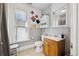 The bathroom includes a vanity, toilet, artwork, mirror, shelving, and window at 1365 Clayton St, Denver, CO 80206