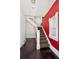 Warm entryway featuring hardwood floors, a classic staircase, and a vibrant red accent wall at 1365 Clayton St, Denver, CO 80206