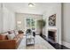 Cozy living room featuring a decorative fireplace, stylish furniture, and large window offering plenty of natural light at 1365 Clayton St, Denver, CO 80206