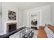 Bright living room with a cozy fireplace, stylish leather sofa, and open access to the dining area for seamless entertaining at 1365 Clayton St, Denver, CO 80206