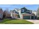 Inviting two-story home showcasing green siding, brick accents, and a well-maintained lawn and landscaping at 2829 S Fig St, Lakewood, CO 80228