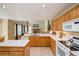 Open-concept kitchen with light wood cabinets, white countertops, an island, and seamless flow to the living room at 2829 S Fig St, Lakewood, CO 80228
