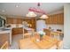 Bright kitchen featuring light wood cabinetry, white appliances, and a charming dining area with a decorative chandelier at 2829 S Fig St, Lakewood, CO 80228