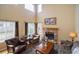 Comfortable living room with vaulted ceilings, a brick fireplace, and large windows offering natural light and backyard views at 2829 S Fig St, Lakewood, CO 80228