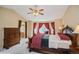 Inviting main bedroom showcasing a bay window, dark wood furnishings, and a glimpse into the en-suite bathroom at 2829 S Fig St, Lakewood, CO 80228