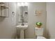 Powder room featuring pedestal sink, toilet, and decorative art with great lighting at 16461 E 119Th Way # B, Commerce City, CO 80022
