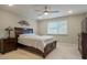 Spacious bedroom featuring a ceiling fan, a large window, and a dark wood bed frame with matching dressers at 16461 E 119Th Way # B, Commerce City, CO 80022