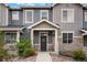 Charming townhome featuring a covered entryway with a wreath-adorned door and stone accents at 16461 E 119Th Way # B, Commerce City, CO 80022